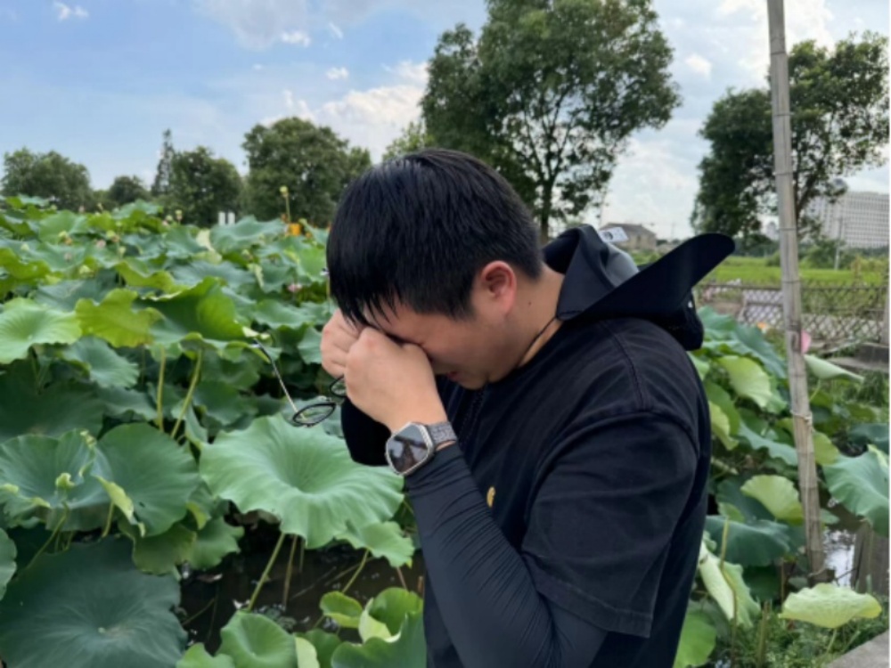電視傳媒新聞中心記者吳金誠在采訪中擦拭汗水.jpg
