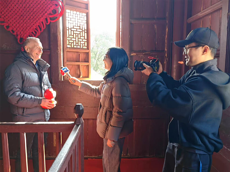 正月初一記者徐揚(yáng)、王肅保國寺采訪外國友人體驗(yàn)中國新春民俗敲鐘.jpg